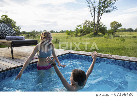 Brother and sister, Two children swimming in small pool at a safari camp Brother and sister, Two children swimming in small pool at a safari camp 67396430
