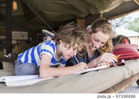 Brother and sister doing homework together in a tented camp in Botswana Brother and sister doing homework together in a tented camp in Botswana 67396886