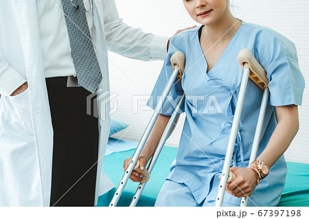 Doctor takes care of patient in crutch at hospital 67397198