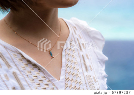お魚のネックレスとショートカットの女性 67397287