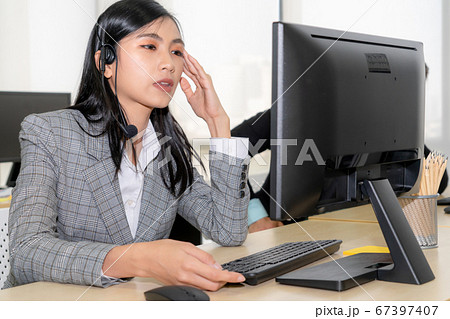 Business people wearing headset feel unhappy working in office Business people wearing headset feel unhappy working in office 67397407