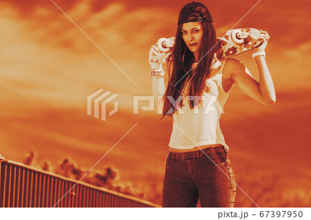 Teenage girl skater riding skateboard on street. Teenage girl skater riding skateboard on street. 67397950