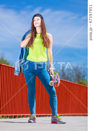Teenage girl skater riding skateboard on street. 67397951