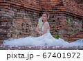 Thai young women portrait in Thai traditional dress at old temple, there is a garland in here hand, Chiangmai Thailand. 67401972