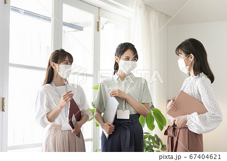 マスクをしたまま話す3人の若い女性 ビジネスシーンイメージ マスクをしたまま話す3人の若い女性 ビジネスシーンイメージ 67404621