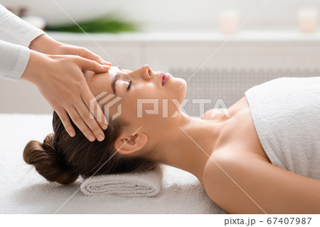 Young woman getting relaxing head massage at spa Young woman getting relaxing head massage at spa 67407987