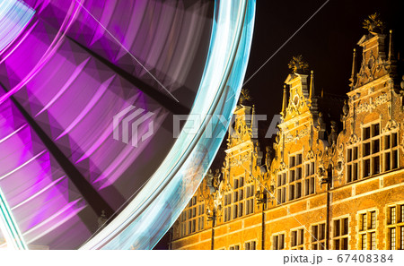 Beautiful view of the Ferris wheel at night. Night illumination of the high Ferris wheel. A long exposition against the background of an old building. Beautiful view of the Ferris wheel at night. Night illumination of the high Ferris wheel. A long exposition against the background of an old building. 67408384
