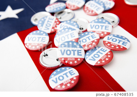 Patriotic pile of button pins on US flag background 67408535