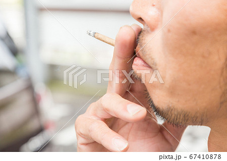 煙草を吸う男性の口元 67410878