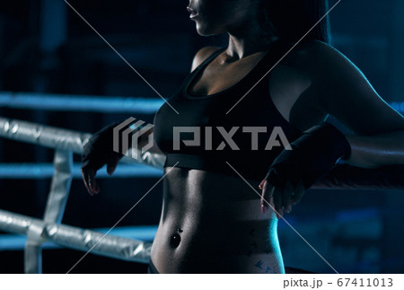 Female fighter posing near ring. 67411013
