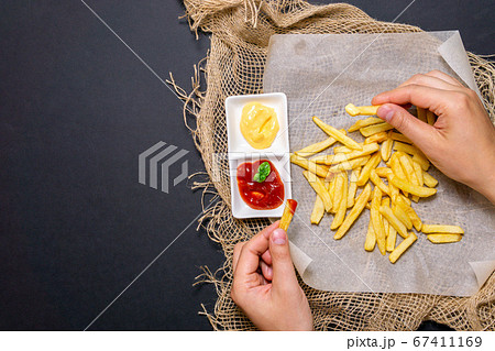 fries-fried potatoes with cheese sauce, ketchup on a black background with cheese sauce. vertical photo fries-fried potatoes with cheese sauce, ketchup on a black background with cheese sauce. vertical photo 67411169