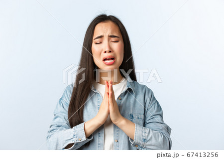 Lifestyle, people emotions and beauty concept. Desperate sad and clingy asian girl sobbing and crying while begging help, apologizing with hands in plead, telling how sorry she is 67413256