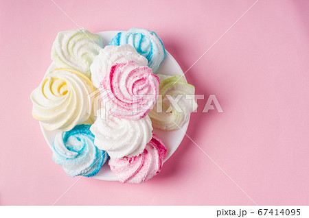Homemade sweet colored meringue on pink Homemade sweet colored meringue on pink 67414095