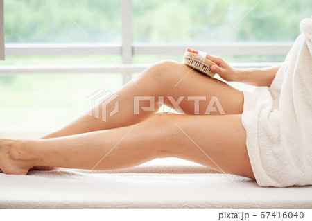 Cellulite treatment, woman arm holding dry brush to top of her leg. Cellulite treatment, woman arm holding dry brush to top of her leg. 67416040