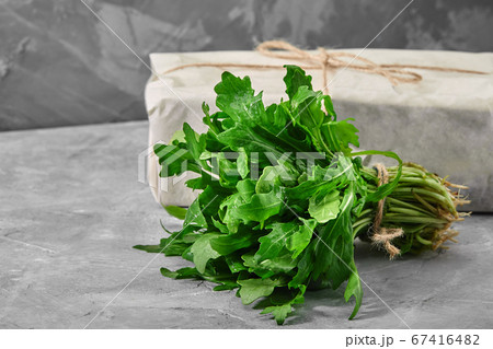 Fresh arugula leaves in a cup on concrete background. Healthy and fresh salad. Organic and natural food concept. Light background. Flat lay. 67416482