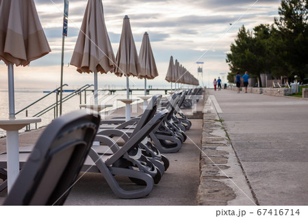 sunset at seaside empty beach and closed umbrellas sunset at seaside empty beach and closed umbrellas 67416714