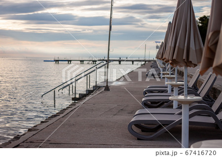 sunset at seaside empty beach and closed umbrellas 67416720