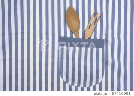 エプロンのポケットに入れたフォークとスプーン 67416901