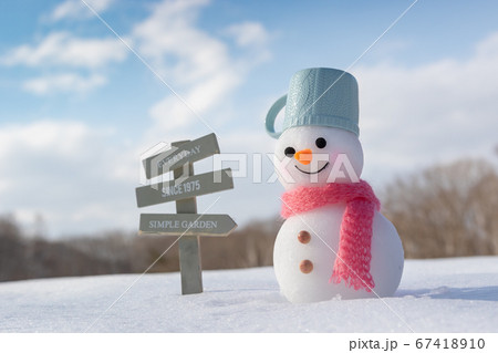 案内板の立つ雪原と雪だるま 67418910