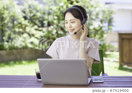 庭でテレワークをする若い女性 庭でテレワークをする若い女性 67419400