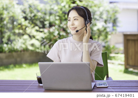 庭でテレワークをする若い女性 67419401