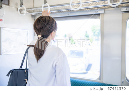 電車のつり革につかまる女性の写真素材 [67421570] - PIXTA