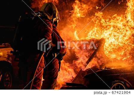 Firefighters spraying down fire flame from car Firefighters spraying down fire flame from car 67421904