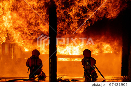 Firefighters use water fog spraying down fire 67421905