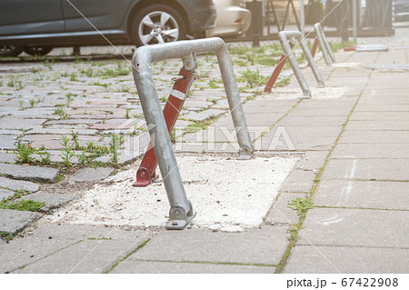 Parking barrier at parking place, cars parked. Pavement with grass Parking barrier at parking place, cars parked. Pavement with grass 67422908