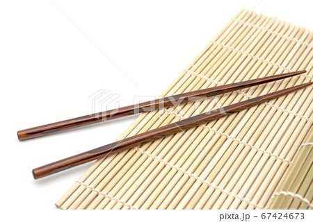 Chopsticks on black bamboo mat, high angle, background 67424673