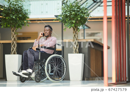 Disabled man talking on the phone 67427579