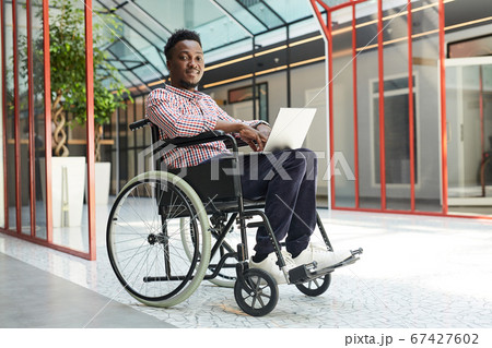 Disabled man working on laptop 67427602