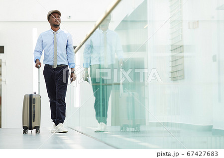 Businessman with luggage at the airport 67427683