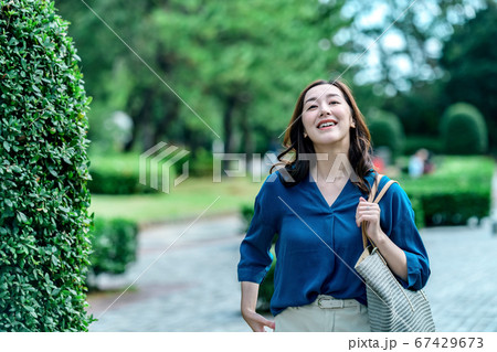 公園を歩く若いカジュアル衣装を着た主婦のポートレート 公園を歩く若いカジュアル衣装を着た主婦のポートレート 67429673
