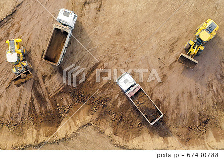 Excavator loading soil onto an Articulated hauler Truck 67430788