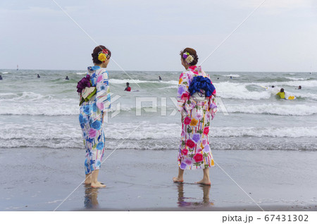 波打ち際で遊ぶ二人の浴衣の女性 波打ち際で遊ぶ二人の浴衣の女性 67431302
