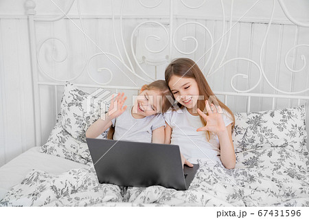 two sisters talk via video connection on computer 67431596