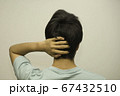 頭に手を当てる男性 67432510