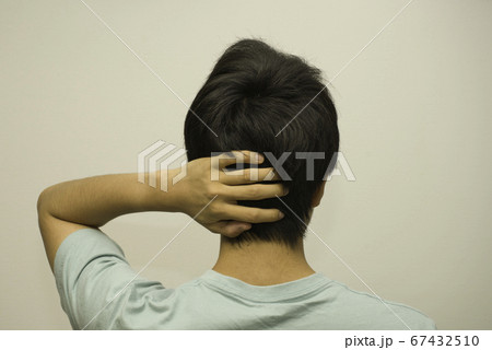 頭に手を当てる男性 67432510