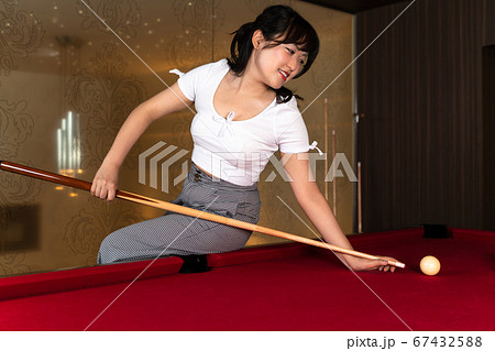 ビリヤードを楽しむ若い女性の写真素材