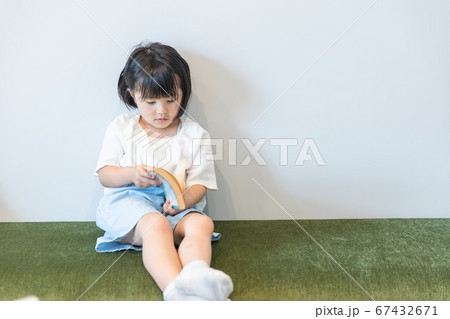 小さい女の子が本を一人で読んでいる　girl 虐待　kids 67432671