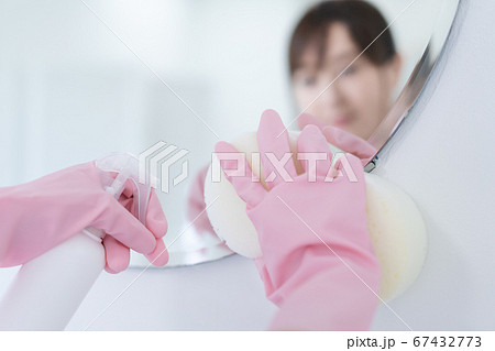 洗面所で鏡を除菌する若い女性 67432773