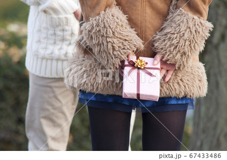 プレゼントを渡す女性の後姿 67433486