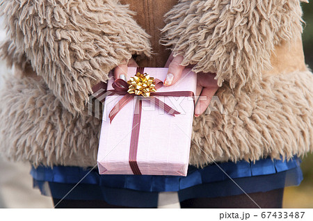 プレゼントを渡す女性の後姿 67433487