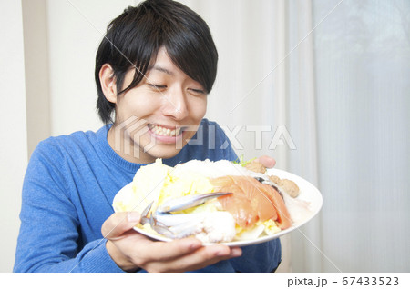 鍋の具材を持つ男性 67433523