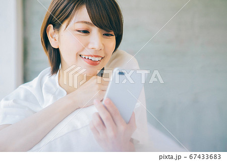 寝転がってスマホを使う女性(※婚活、結婚相談所等のサイトやアプリなどでのご利用はお控えください) 寝転がってスマホを使う女性(※婚活、結婚相談所等のサイトやアプリなどでのご利用はお控えください) 67433683