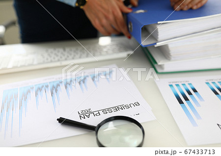 In office on table is business plan 2021 and folders with documents. In office on table is business plan 2021 and folders with documents. 67433713