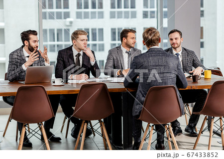young caucasian men gathered to hold business meeting together young caucasian men gathered to hold business meeting together 67433852