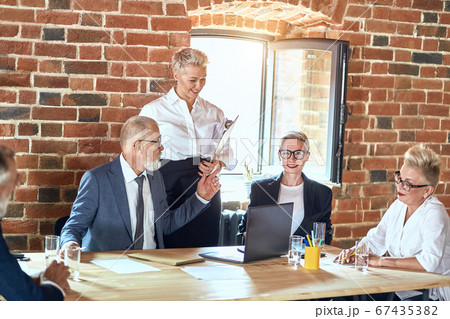 Group of business people brainstorming together in meeting room 67435382