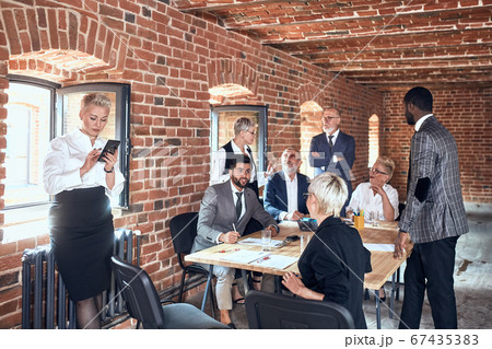 Group of business people brainstorming together in meeting room Group of business people brainstorming together in meeting room 67435383
